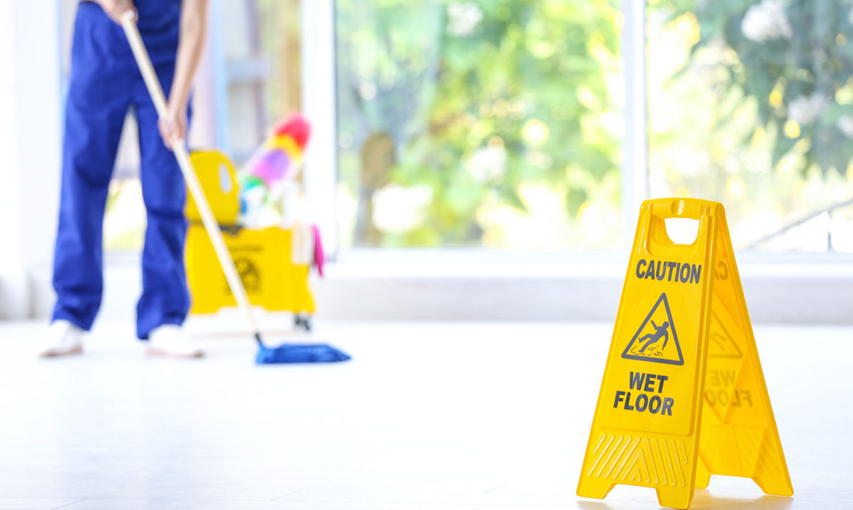 Safety sign with phrase Caution wet floor and cleaner indoors. C